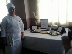 Dayana in her chef uniform with her delicious looking creations